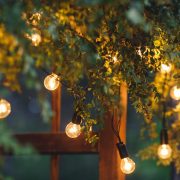 close-up of an electric lamp, a garland on a wedding arch in the evening.